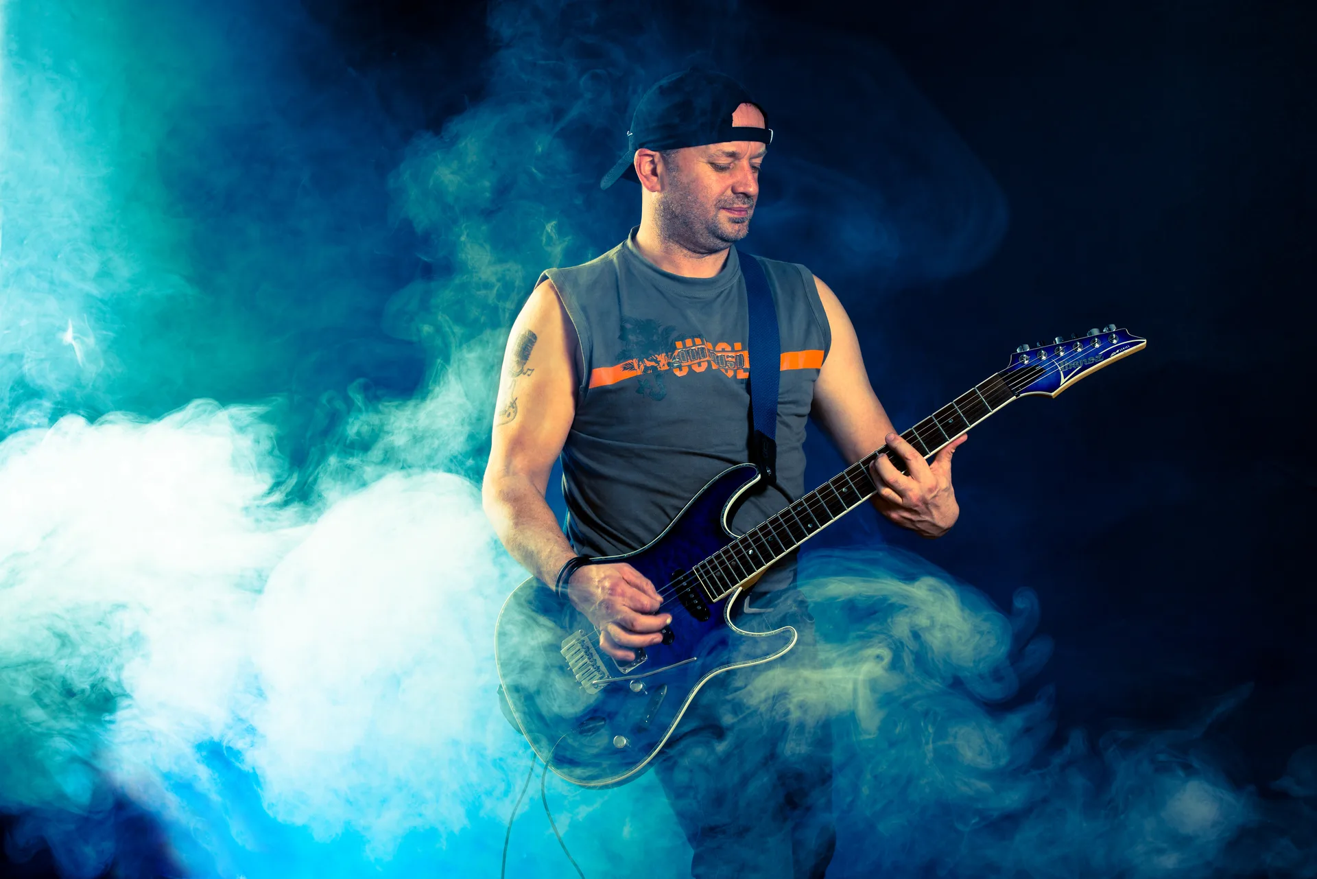 Gerald Stefan Allmann spielt E-Gitarre auf der Bühne mit Nebel und Bühnenlicht