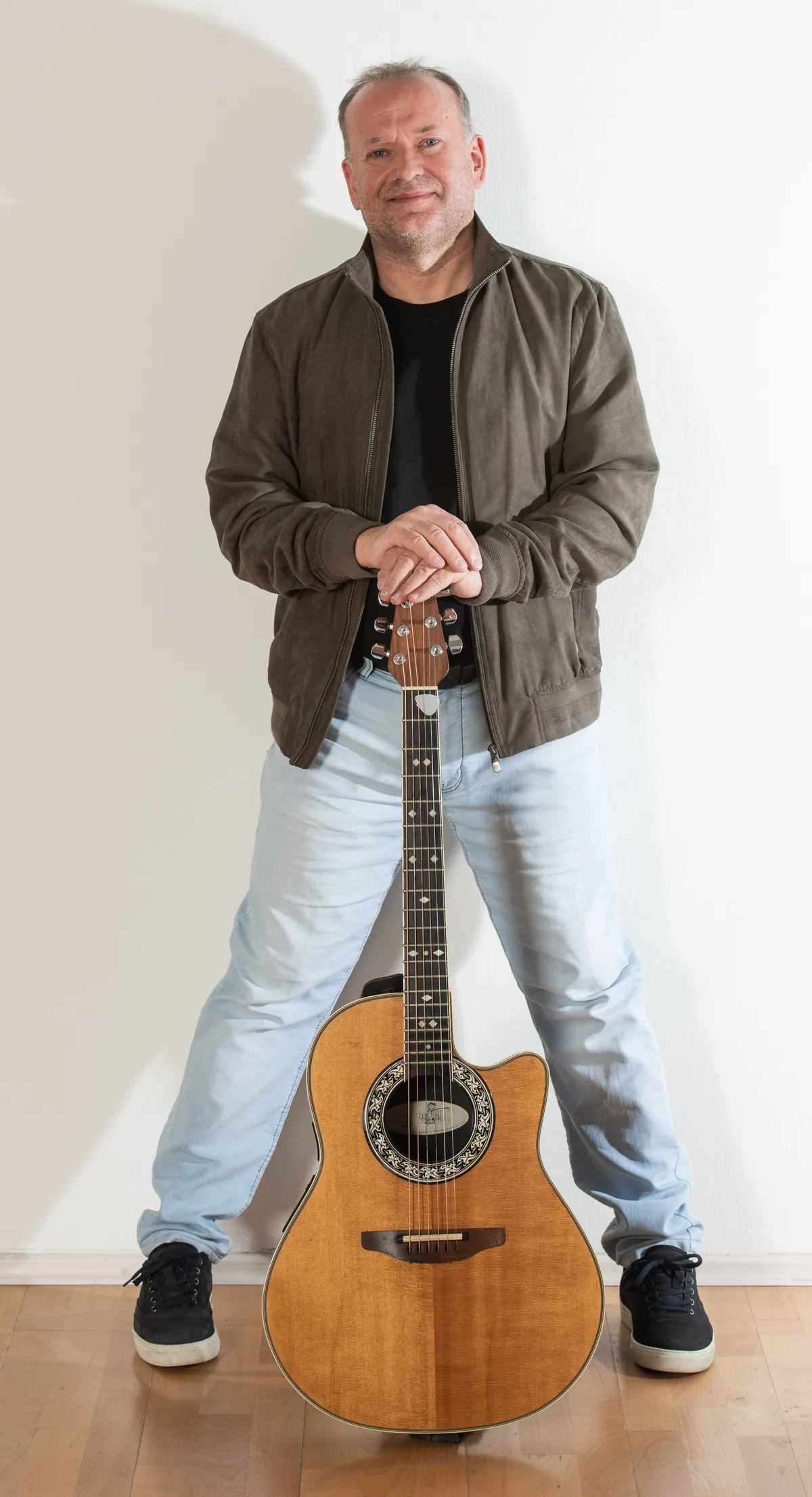 Gerald Stefan Allmann stehend mit Akustikgitarre