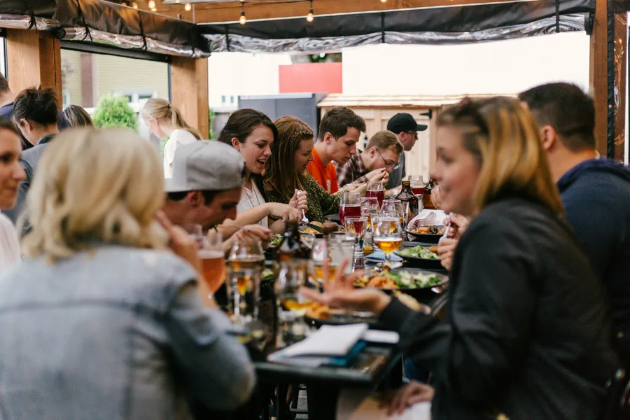 Gruppe beim gemeinsamen Essen und Feiern auf einer überdachten Terrasse